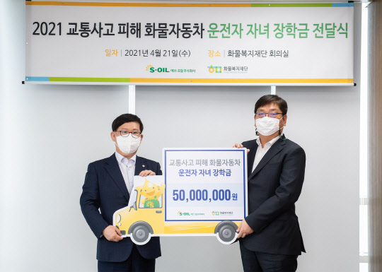 21일 서울 역삼동 소재 화물복지재단에서 서정규(오른쪽) 에쓰오일 부사장이 조한권 화물복지재단 사무처장에게 교통사고 피해 화물차 운전자 자녀를 위한 장학금 5000만원을 전달한 뒤 기념사진을 찍고 있다. <에쓰오일 제공>